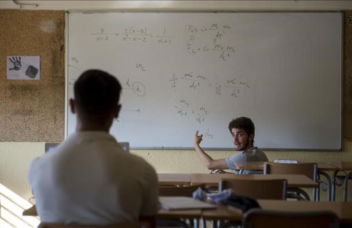 Un monitor charla con un estudiante de secundaria en una clase de refuerzo estival en el instituto Sant Andreu de Barcelona.