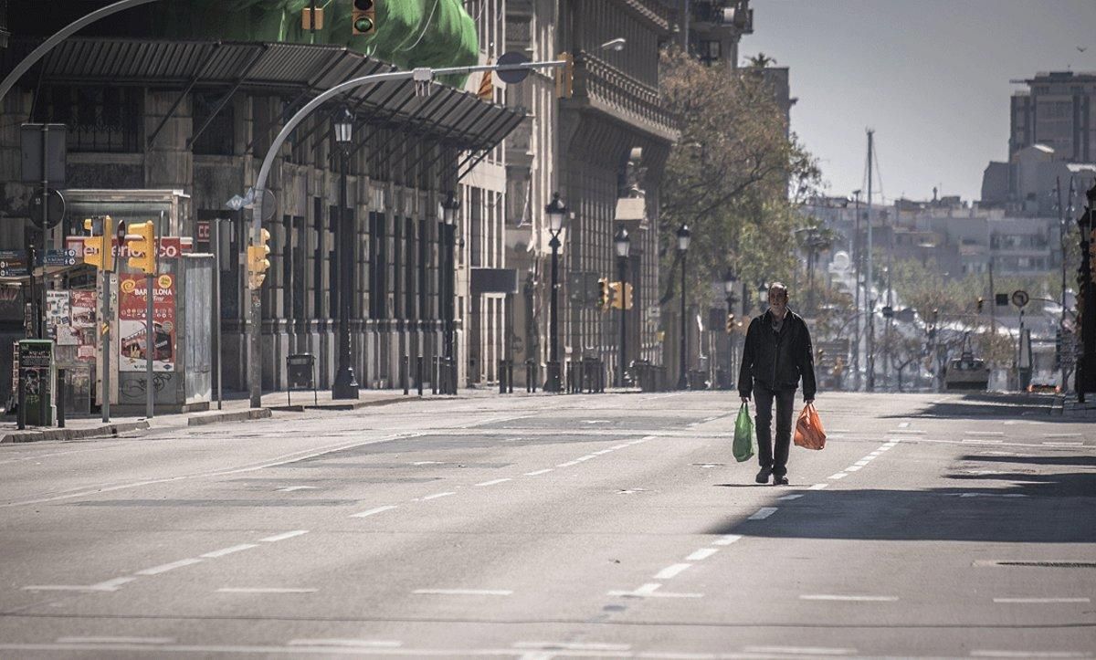 Un hombre regresa de la compra por una Via Laietana completamente vacía por el estado de alarma. Un hombre regresa de la compra por una Via Laietana completamente vacía por el estado de alarma.