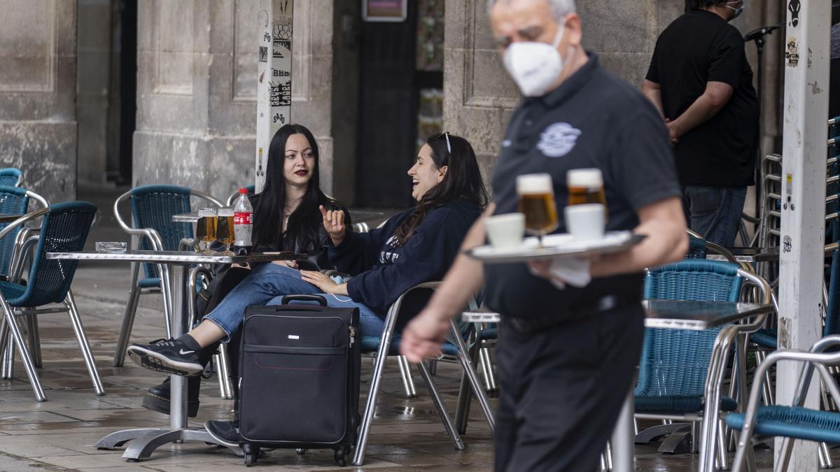 DOS TURISTAS EN LA TERRAZA DE UN BAR DE LA PL REAL DOS TURISTAS EN LA TERRAZA DE UN BAR DE LA PL REAL