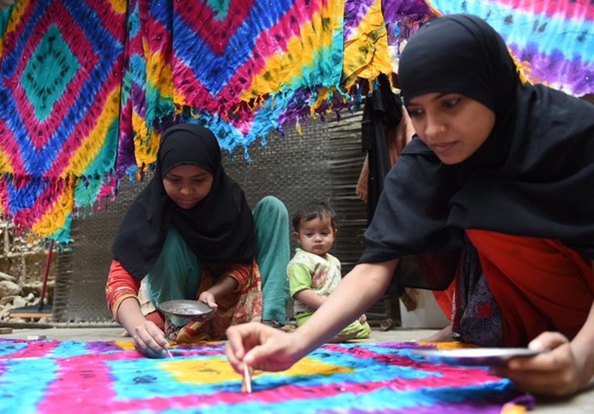 Trabajadoras paquistanís confeccionan alfombras en su casa de Karachi, este lunes.