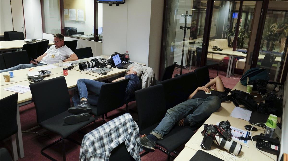 Periodistas descansan esperando el final de la reunión de los líderes europeos en Bruselas. Periodistas descansan esperando el final de la reunión de los líderes europeos en Bruselas.