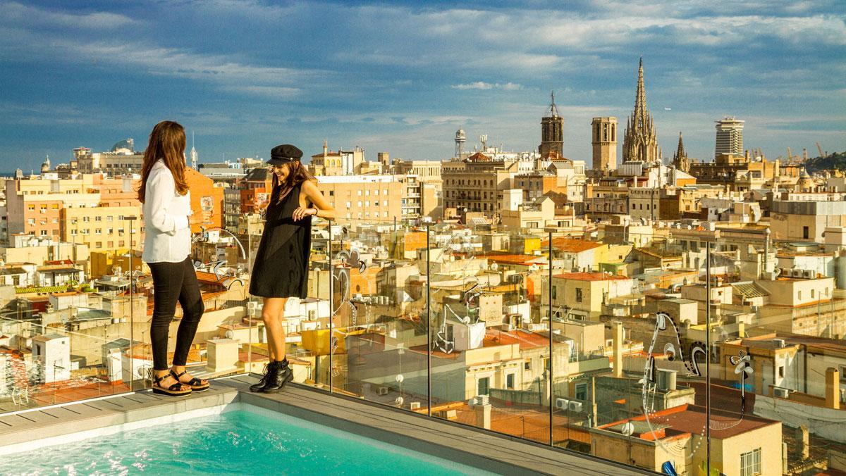 Dos participantes en la pasada edición de la Semana de las Terrazas disfrutan de una copa en la azotea del Yurbban Trafalgar Hotel, con unas vistas increíbles de Barcelona.