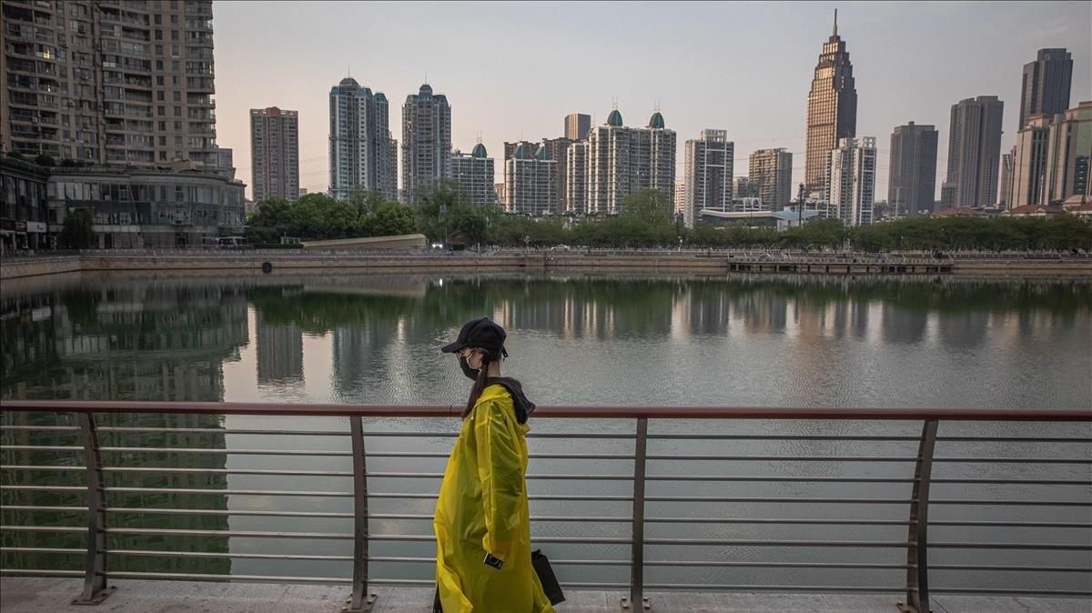 Una mujer camina junto a un lago de Wuhan (China). Una mujer camina junto a un lago de Wuhan (China).