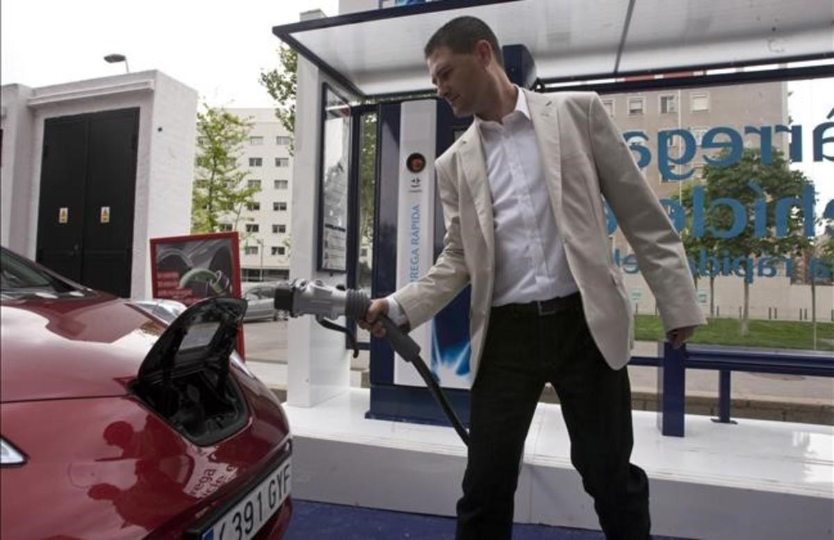 Un conductor carga su coche eléctrico en un punto de recarga de Barcelona. 