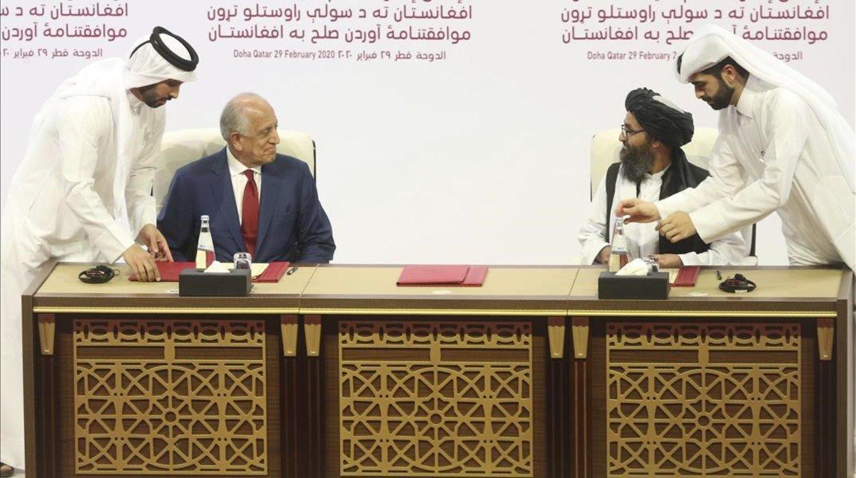 Firma del acuerdo de paz entre el enviado estadounidense, Zalmay Khalilz, (izquierda) y el mulá Abdul Ghani Baradar.