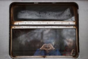 Un niño ucraniano forma un corazón con sus manos a su llegada a la estación de Przemysl, en Polonia.
