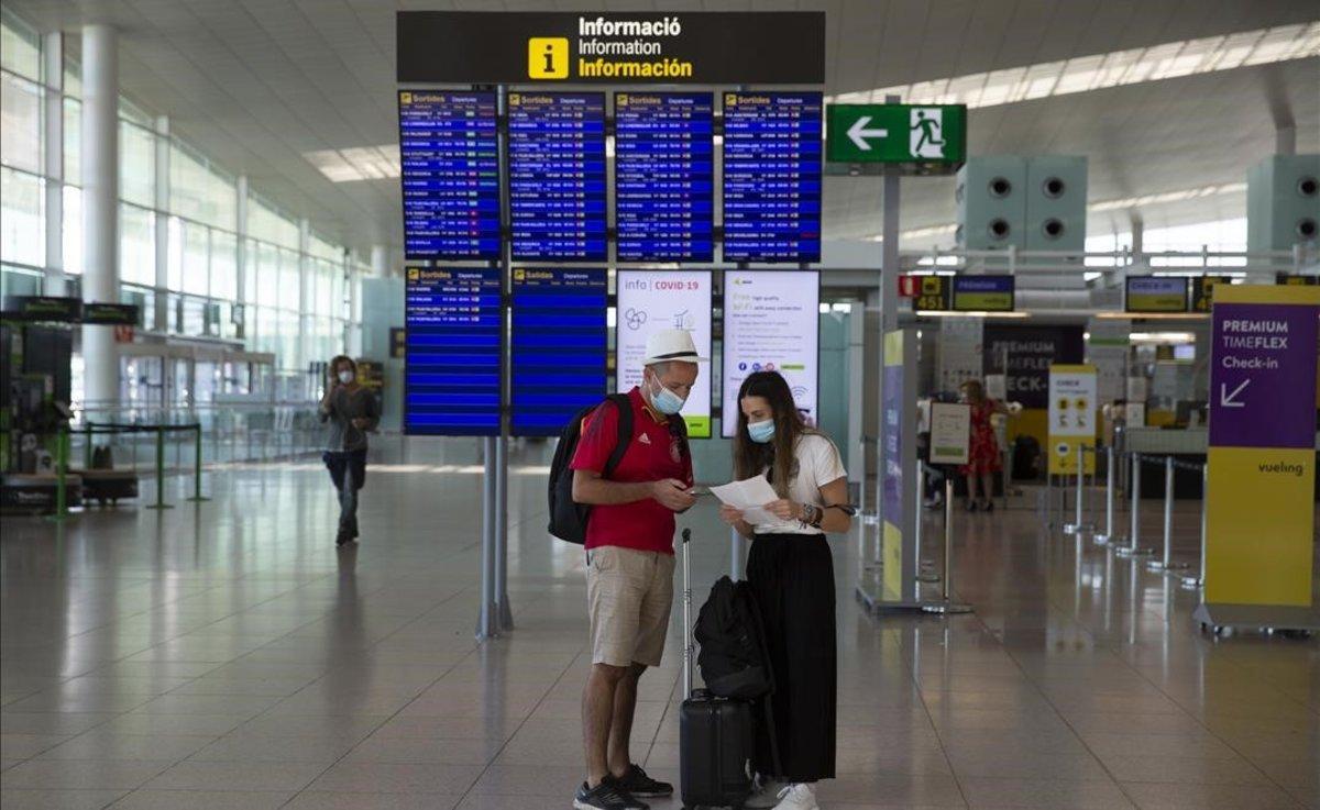 Pasajeros con mascarilla en el aeropuerto de Barcelona.