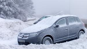 Un coche cubierto de nieve en la carretera de acceso al Puerto de Navacerrada (Madrid), el pasado día 19.
