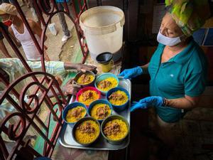 Una trabajadora sirve comidas en un proyecto comunitario en el barrio Los Sitios de La Habana.