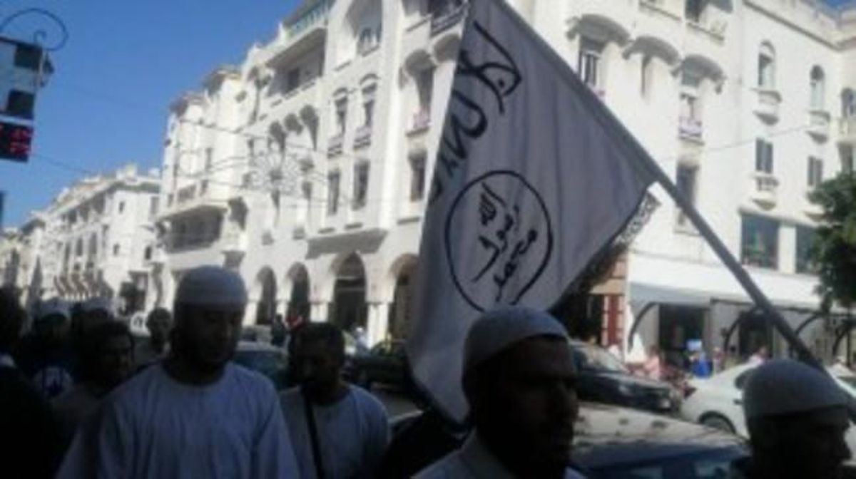 Un grupo de paseantes porta una bandera con los símbolos del Estado Islámico en una avenida de Rabat. Un grupo de paseantes porta una bandera con los símbolos del Estado Islámico en una avenida de Rabat.