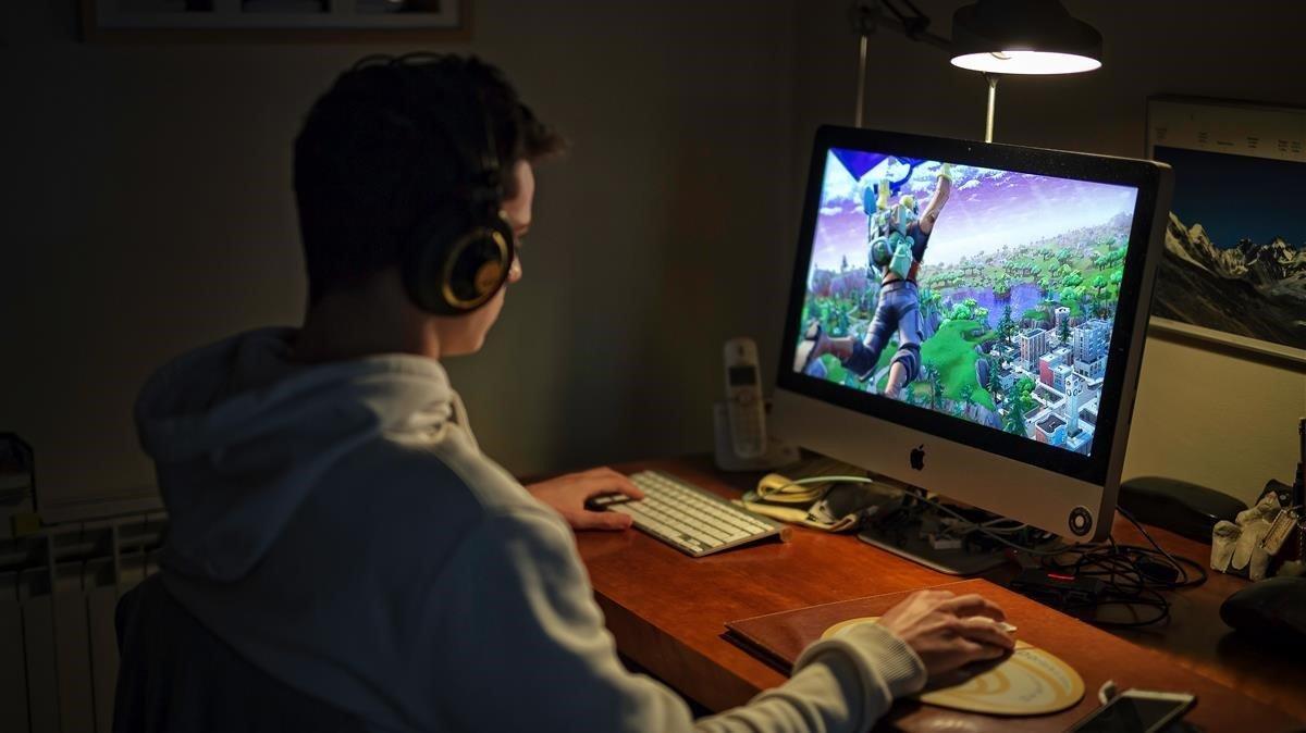 Un niño juega al Fortnite con su ordenador.