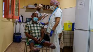 Vacunación de una persona sin hogar en la Fundació Arrels de Barcelona.