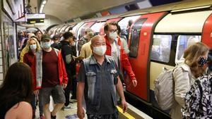 Ciudadanos protegidos por mascarillas en el metro de Londres.