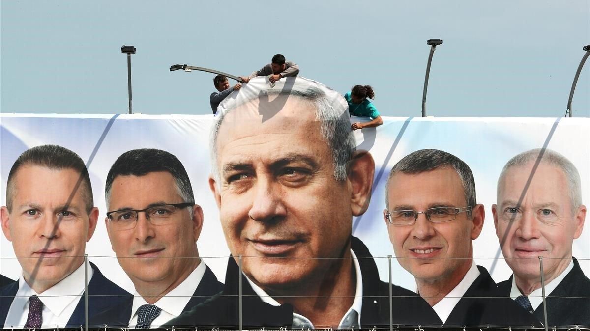 Un grupo de operarios trabaja en una valla publicitaria de propaganda electoral en la que aparece Netanyahu con candidatos de su partido, el Likud, en Jerusalén. Un grupo de operarios trabaja en una valla publicitaria de propaganda electoral en la que aparece Netanyahu con candidatos de su partido, el Likud, en Jerusalén.
