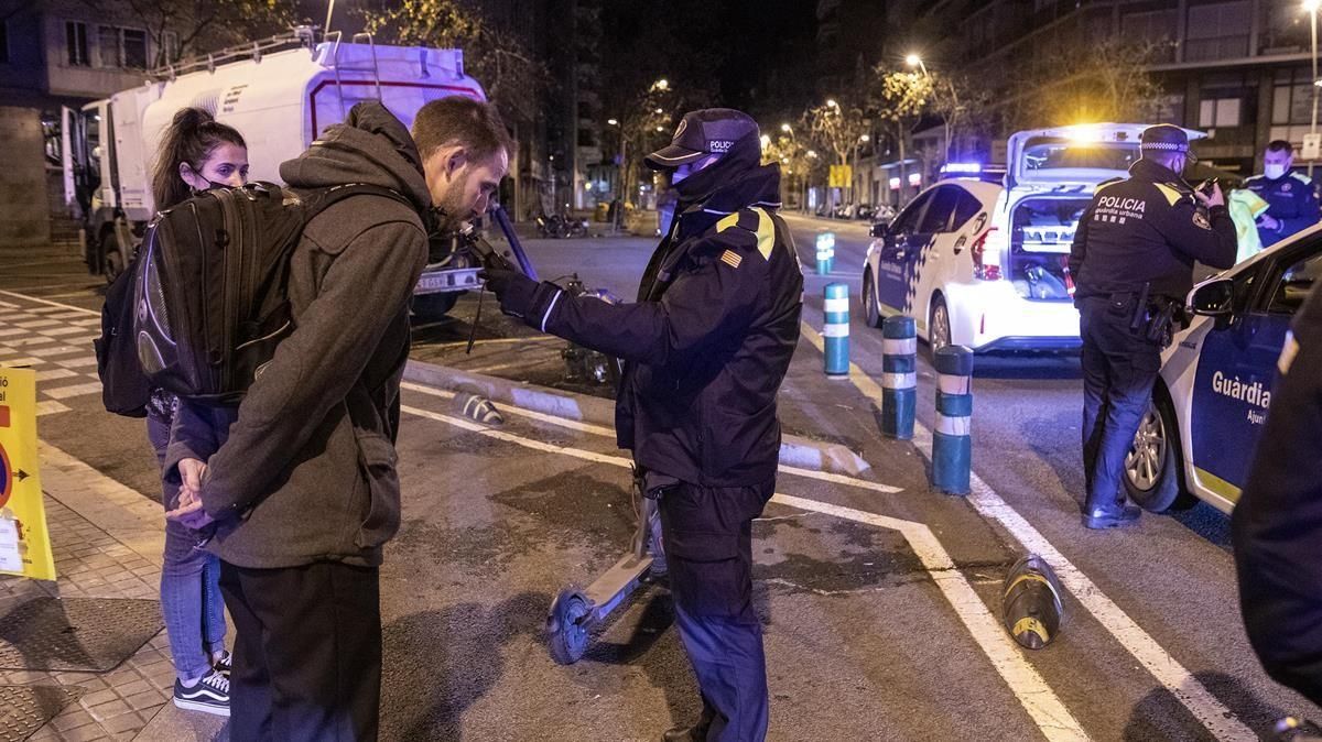 Los agentes de la Guardia Urbana de Barcelona realizan un control de alcoholemia a un conductor de un patinete que circulaba fuera del horario permitido. Los agentes de la Guardia Urbana de Barcelona realizan un control de alcoholemia a un conductor de un patinete que circulaba fuera del horario permitido.