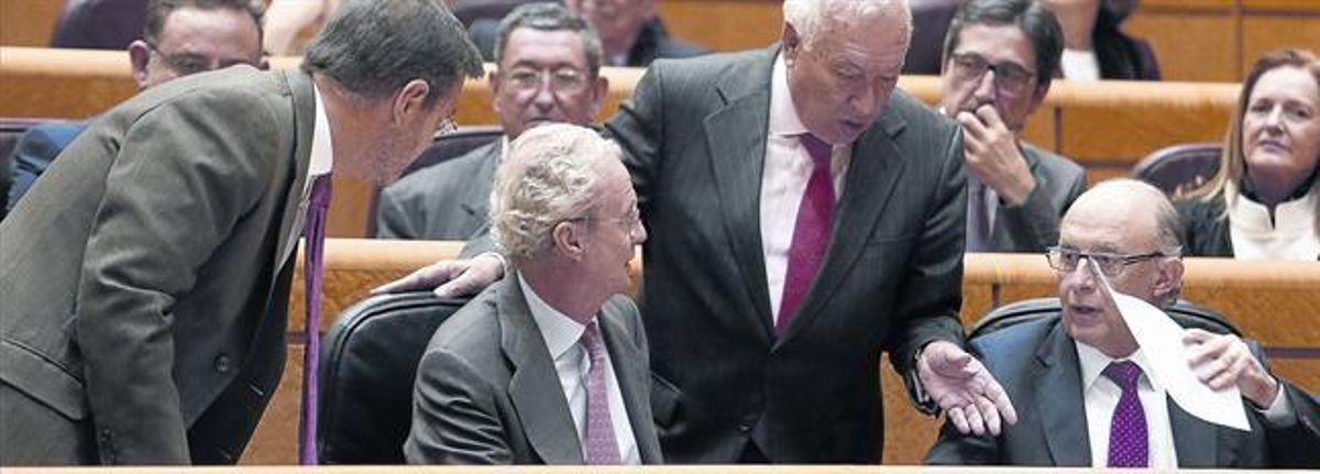 Cristóbal Montoro conversa con los ministros Catalá, Morenés y García Margallo, ayer en el Senado durante la sesión de control al Gobierno. Cristóbal Montoro conversa con los ministros Catalá, Morenés y García Margallo, ayer en el Senado durante la sesión de control al Gobierno.
