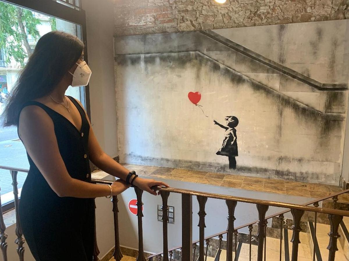 Una mujer contempla la famosa imagen de la niña con el globo. Una mujer contempla la famosa imagen de la niña con el globo.