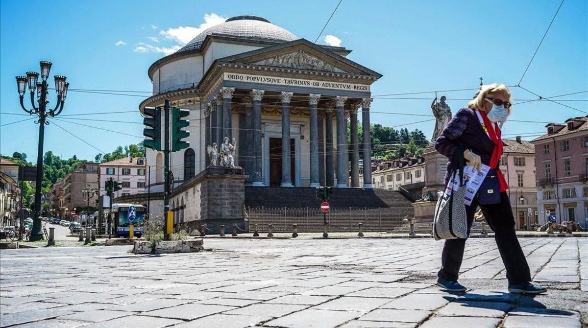 Una mujer con mascarilla ante la iglesia de la Gran Madre di Dio en Turín. Una mujer con mascarilla ante la iglesia de la Gran Madre di Dio en Turín.