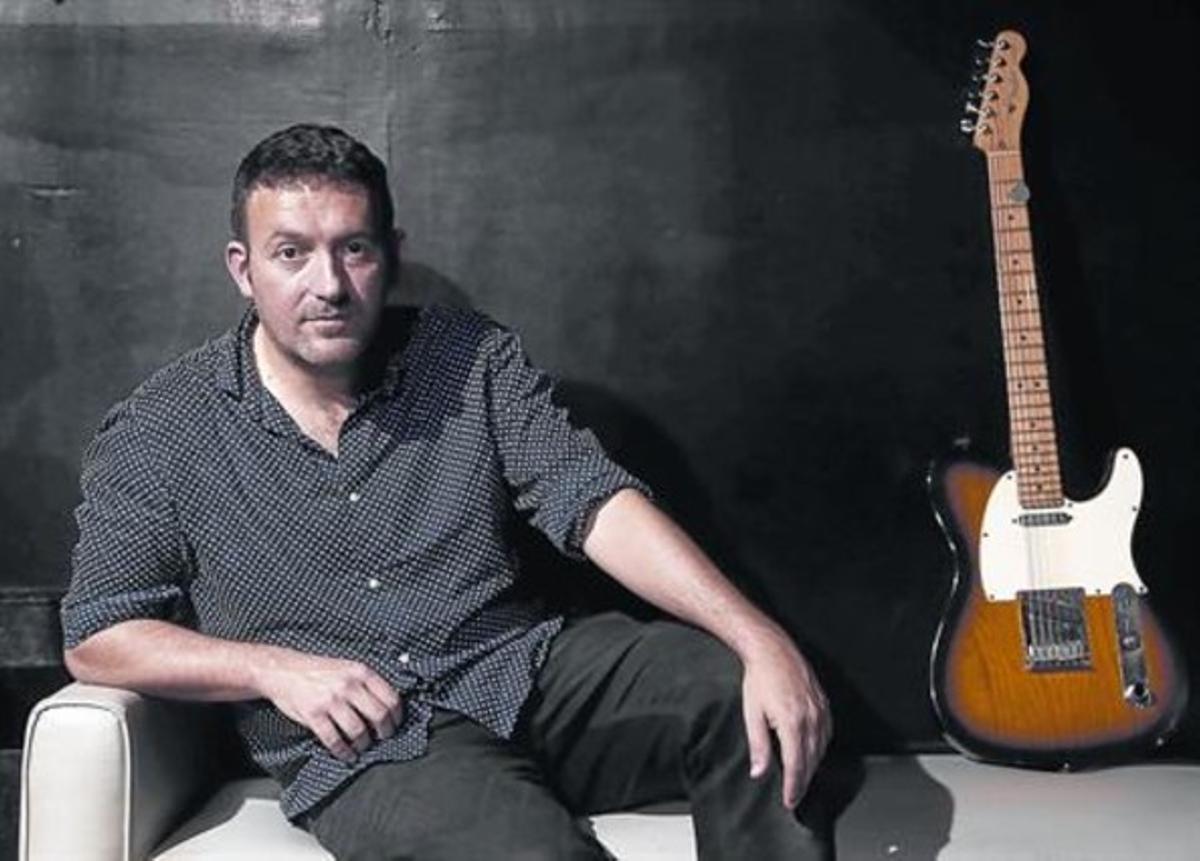 Mikel Santiago, con una guitarraen el club Honky Tonk de Madrid;el rock tiene un papel en su viday en su último libro.