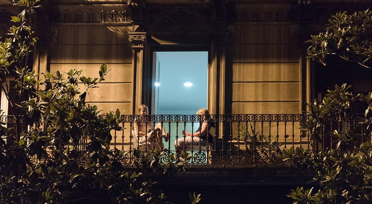 Dos mujeres leen en el balcón de su casa, en Gran de Gràcia. Dos mujeres leen en el balcón de su casa, en Gran de Gràcia.