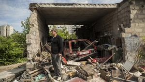 Un residente de Járkov junto a su vehículo y su garaje destruido por un misil ruso.