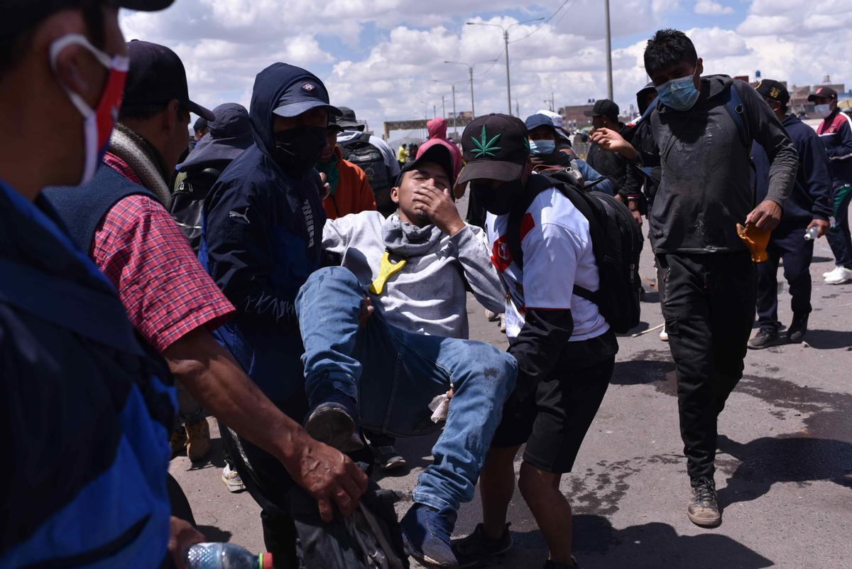 Varias personas asisten a un herido tras los enfrentamientos entre manifestantes y las fuerzas de seguridad en la ciudad peruana de Juliaca (sur).