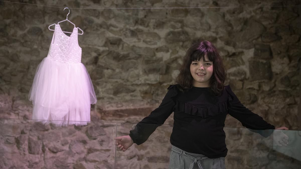 Cora Navarro junto a su primer vestido, en la exposición CORA(JE) del Centre Cívic Pati Llimona Cora Navarro junto a su primer vestido, en la exposición CORA(JE) del Centre Cívic Pati Llimona