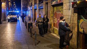 Un hombre cierra su negocio en la calle Joaquín Costa minutos después del toque de queda