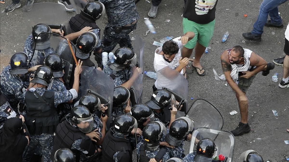 Manifestantes se enfrentan con las fuerzas antidisturbios en Beirut este viernes. Manifestantes se enfrentan con las fuerzas antidisturbios en Beirut este viernes.