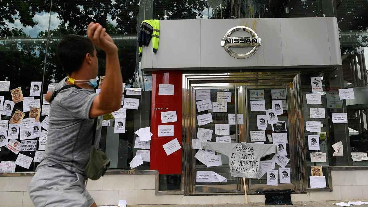 Trabajadores de Nissan empapelan un concesionario de la marca en L’Hospitalet. En la foto, un trabajador lanza un huevo contra una tienda en Barcelona.