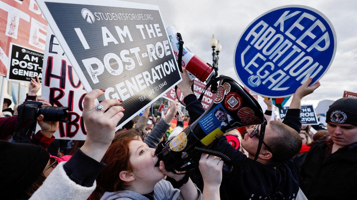 Activistas por el derecho al aborto y manifestantes contra el aborto sostienen carteles durante la Marcha por la Vida, en Washington.