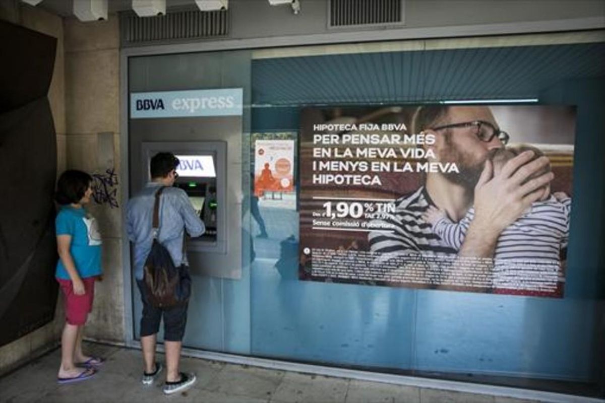 Un cliente de un banco sacando dinero de un cajero automático. Un cliente de un banco sacando dinero de un cajero automático.