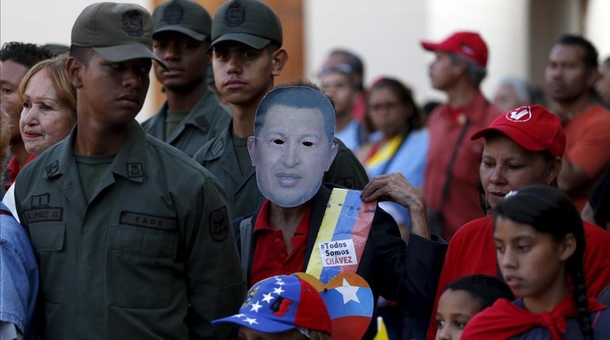 Un seguidor de Maduro lleva una máscara con la imagen del desaparecido Hugo Chávez, en la conmemoración del tercer aniversario de su muerte, en Caracas, el 5 de marzo.
