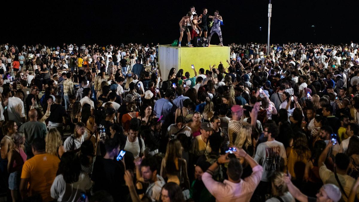 Multitud de personas se reúne para celebrar la verbena de Sant Joan en la playa de Somorrostro. 