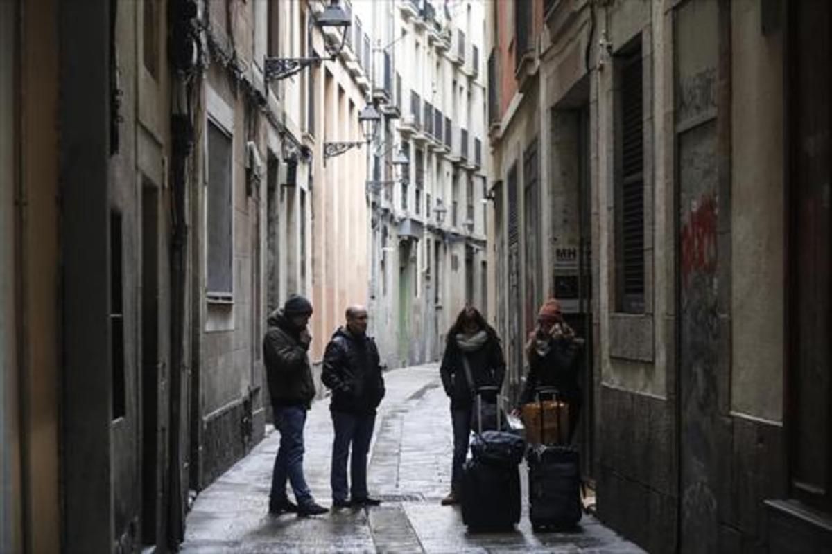Turistas ante un apartamento turístico del barrio Gotic, a finales de enero-