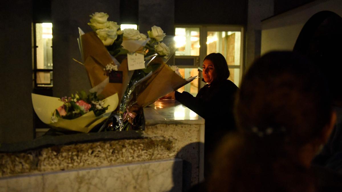 Una mujer enciende una vela al pie del edificio donde fue encontrado el cadáver de Lola, una niña de 12 años el el Distrito 19 de París.