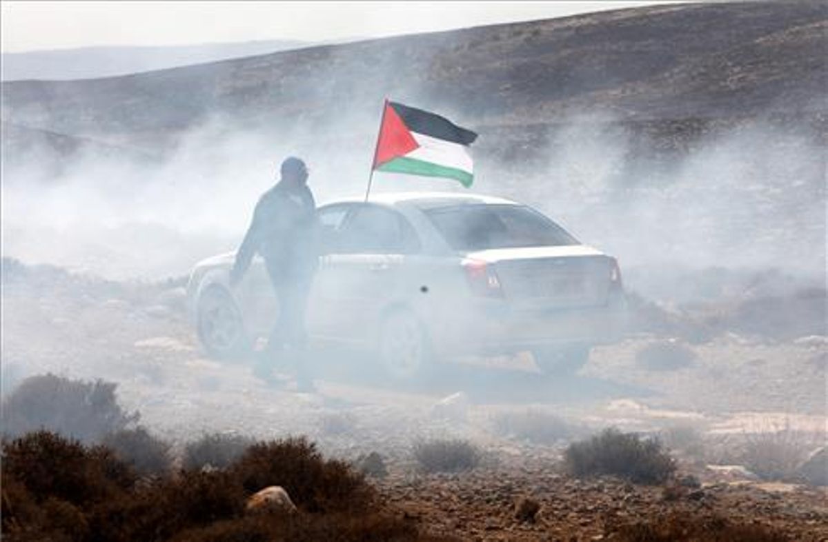 Un hombre ondea la bandera palestina entre gas lacrimógeno en 2019. Un hombre ondea la bandera palestina entre gas lacrimógeno en 2019.