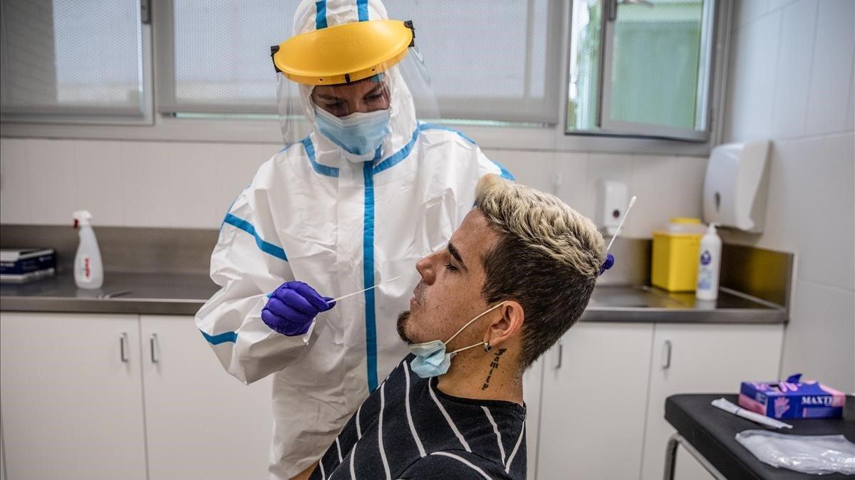 Una enfermera le realiza una prueba PCR a un paciente en el centro de atención primaria (CAP) Roger de Barcelona. Una enfermera le realiza una prueba PCR a un paciente en el centro de atención primaria (CAP) Roger de Barcelona.