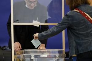 Una mujer deposita su papeleta en la urna en un colegio electoral de París.