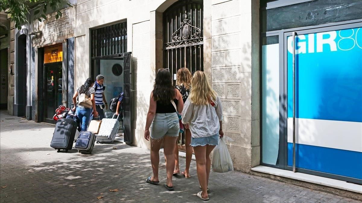 Turistas accediendo a un bloque de pisos turísticos en Barcelona. Turistas accediendo a un bloque de pisos turísticos en Barcelona.