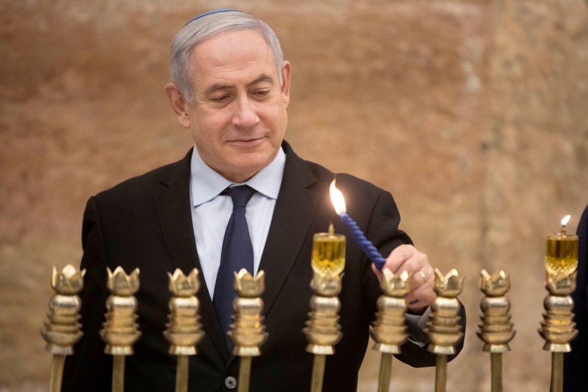 FILE PHOTO: Israeli Prime Minister Benjamin Netanyahu, lights a Hanukkah candle at the Western Wall, the holiest site where Jews can pray in Jerusalem’s old city, December 22, 2019. Sebastian Scheiner/Pool via REUTERS/File Photo FILE PHOTO: Israeli Prime Minister Benjamin Netanyahu, lights a Hanukkah candle at the Western Wall, the holiest site where Jews can pray in Jerusalem’s old city, December 22, 2019. Sebastian Scheiner/Pool via REUTERS/File Photo