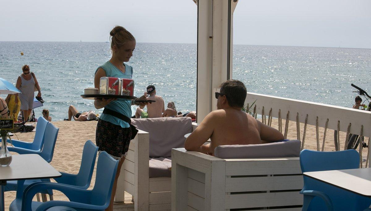 Una camarera en un chiringuito de playa trabajando durante el verano, en Badalona. Una camarera en un chiringuito de playa trabajando durante el verano, en Badalona.