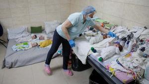 Una enfermera se dispone a abrigar a uno de los bebés nacidos por gestación subrogada, en las instalaciones-refugio de la clínica BioTexCom en Kiev.
