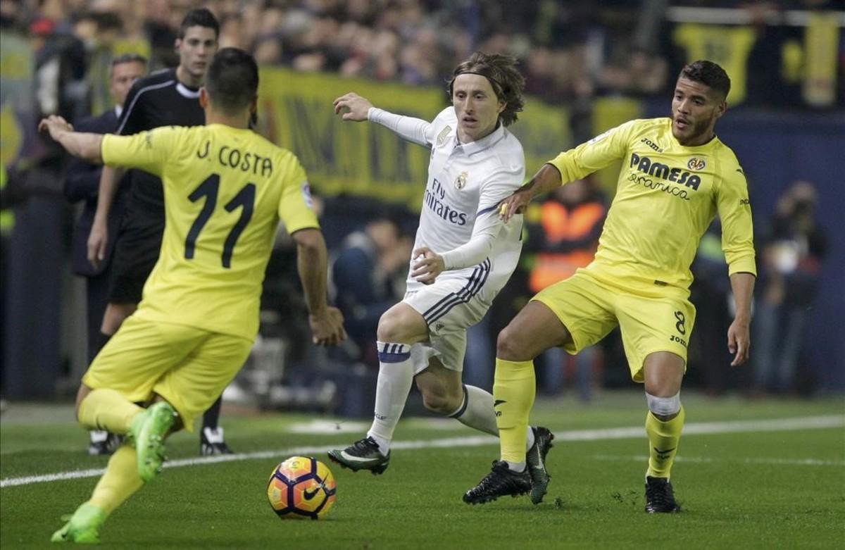 Modric intenta avanzar entre Dos Santos y Jaume Costa.