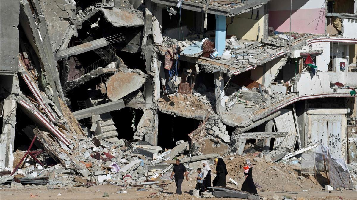 Una familia atraviesa una calle con edificios destrozados en Gaza, en el marco del enfrentamiento entre Hamás e Israel en 2014. Una familia atraviesa una calle con edificios destrozados en Gaza, en el marco del enfrentamiento entre Hamás e Israel en 2014.