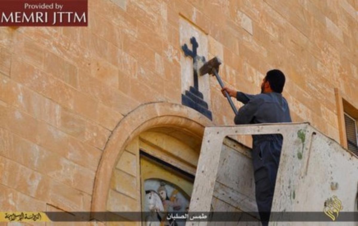 Un yihadista retira la cruz de una iglesia en el norte de Irak.