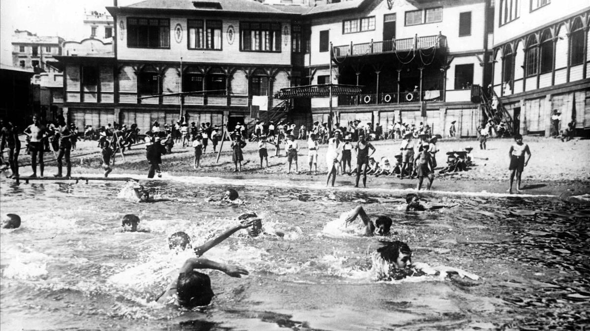 La Escola del Mar, al fondo, obra de Josep Goday, y varios de sus alumnos, en primer plano, en la hora del baño. La Escola del Mar, al fondo, obra de Josep Goday, y varios de sus alumnos, en primer plano, en la hora del baño.