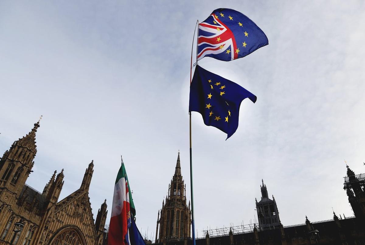 Un manifestante sostiene las bandera de Gran Bretaña y de la UE en una protesta ante el Parlamento británico, en Londres.