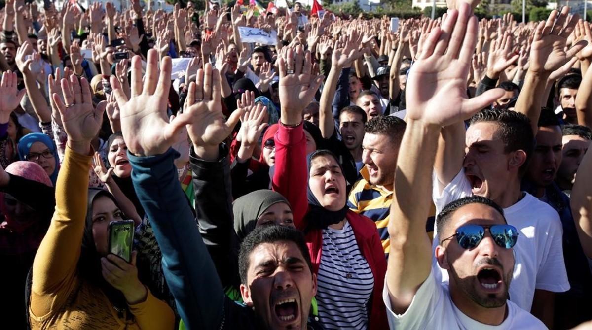 Jóvenes con los brazos en alto durante la masiva manifestación en Alhucemas, en el norte de Marruecos, el 18 de mayo.