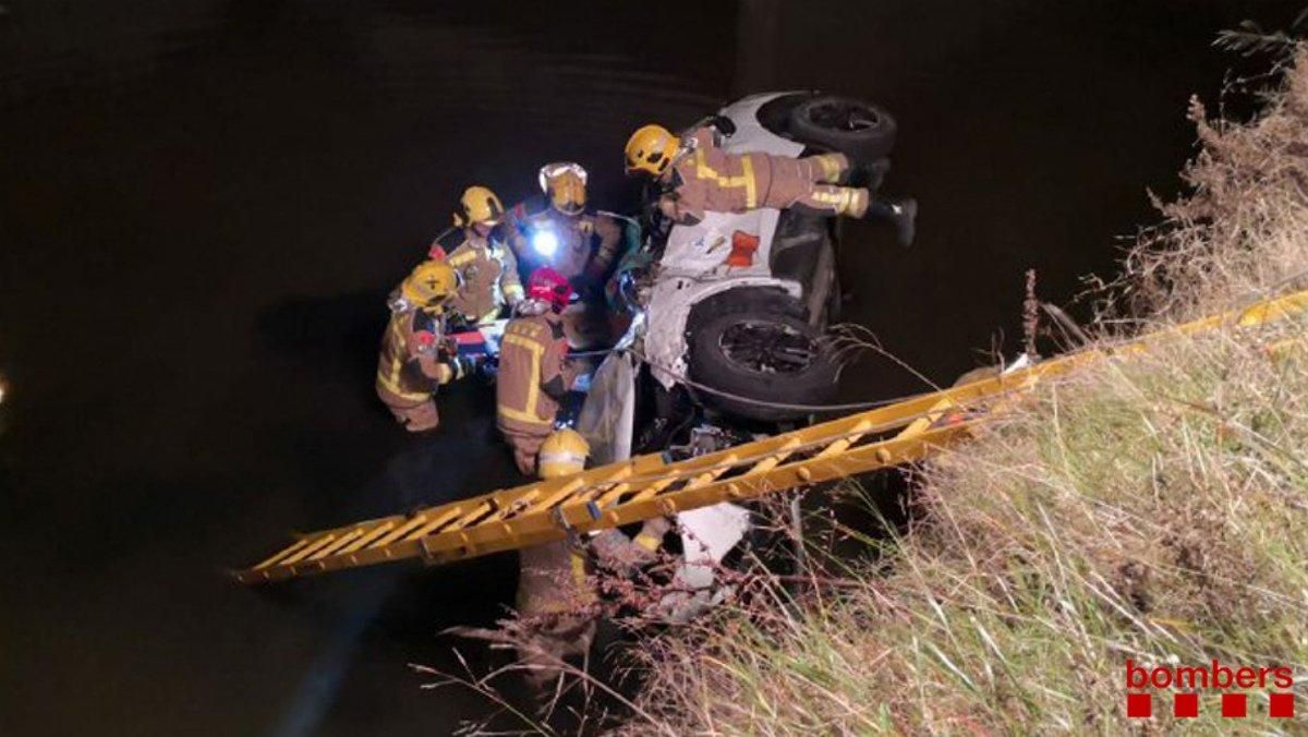 Los Bomberos retiran el coche caído a un canal de El Prat. Los Bomberos retiran el coche caído a un canal de El Prat.
